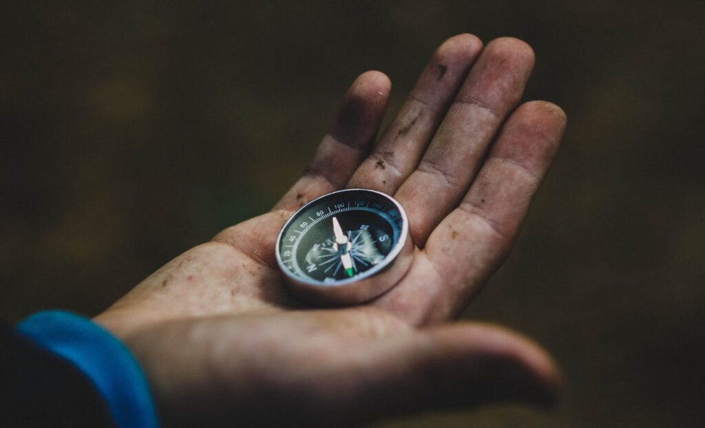 A man holding a compass for navigation